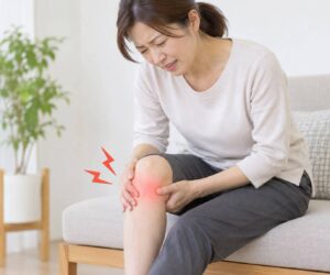 膝の内側の痛みを感じて膝を押さえる女性のイメージ