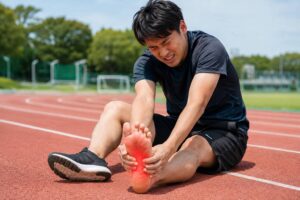 ランニング中に足底筋膜炎による足裏の痛みを感じている男性
