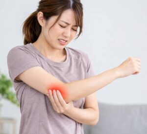 テニス肘で肘の外側に痛みを感じている女性